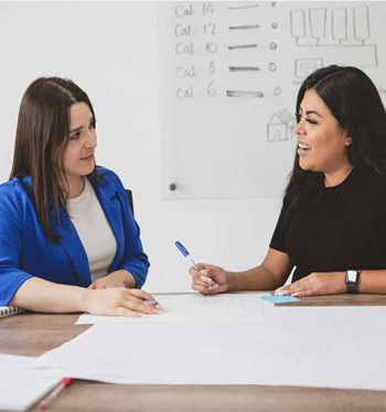 Two people sitting at a table working collaboratively.